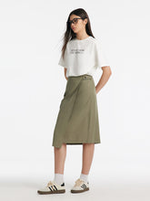 A lady wears a green wrap skirt.